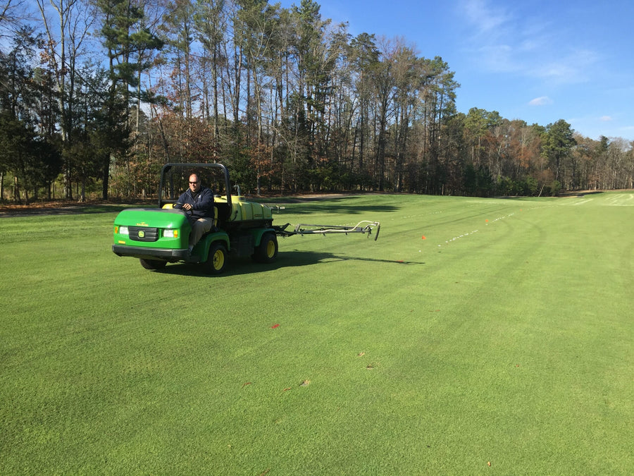 Utility vehicle spraying a golf fairway as part of a soil health program